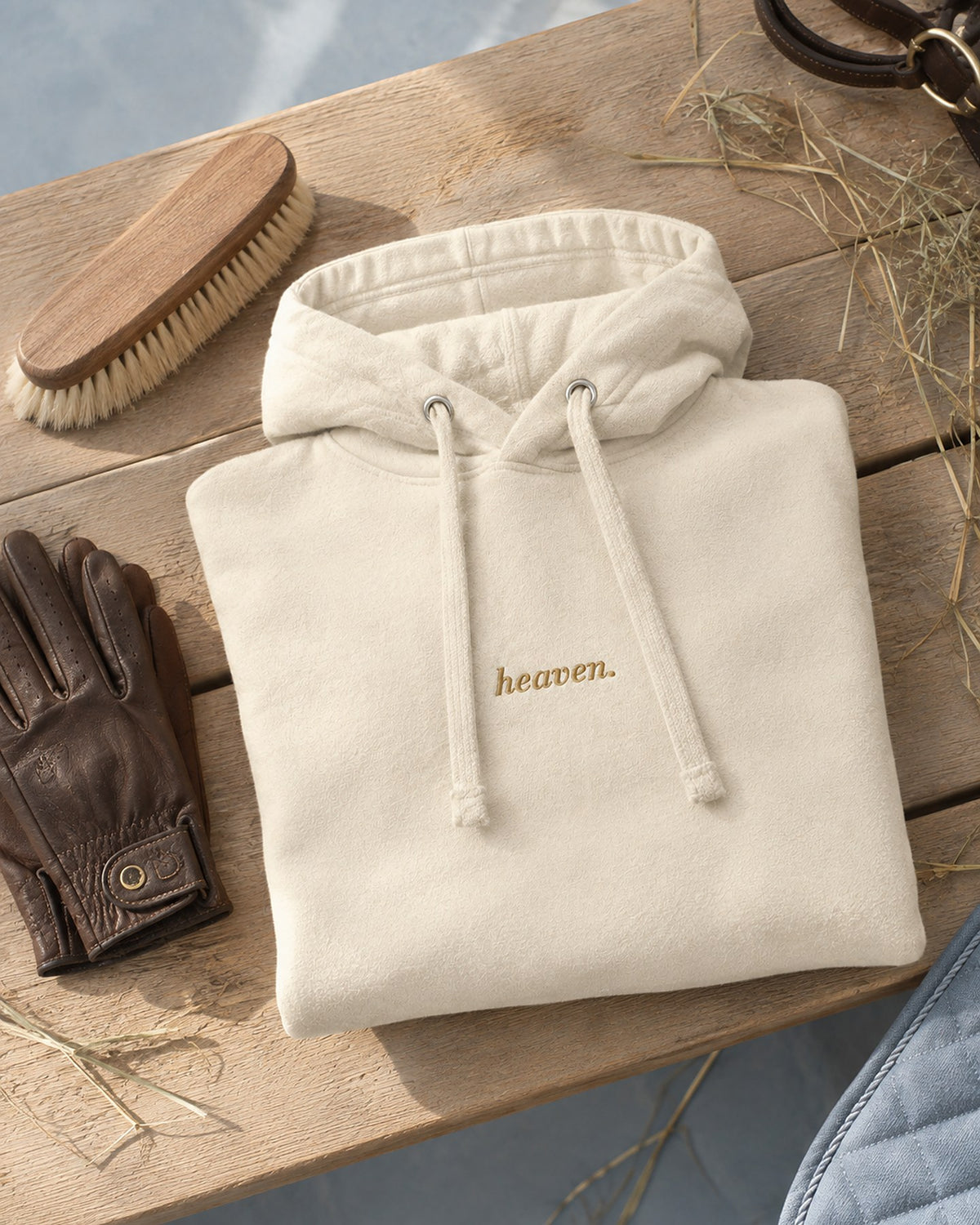Sweat heaven. plié sur un banc en bois avec une brosse, des gants en cuir et du foin
