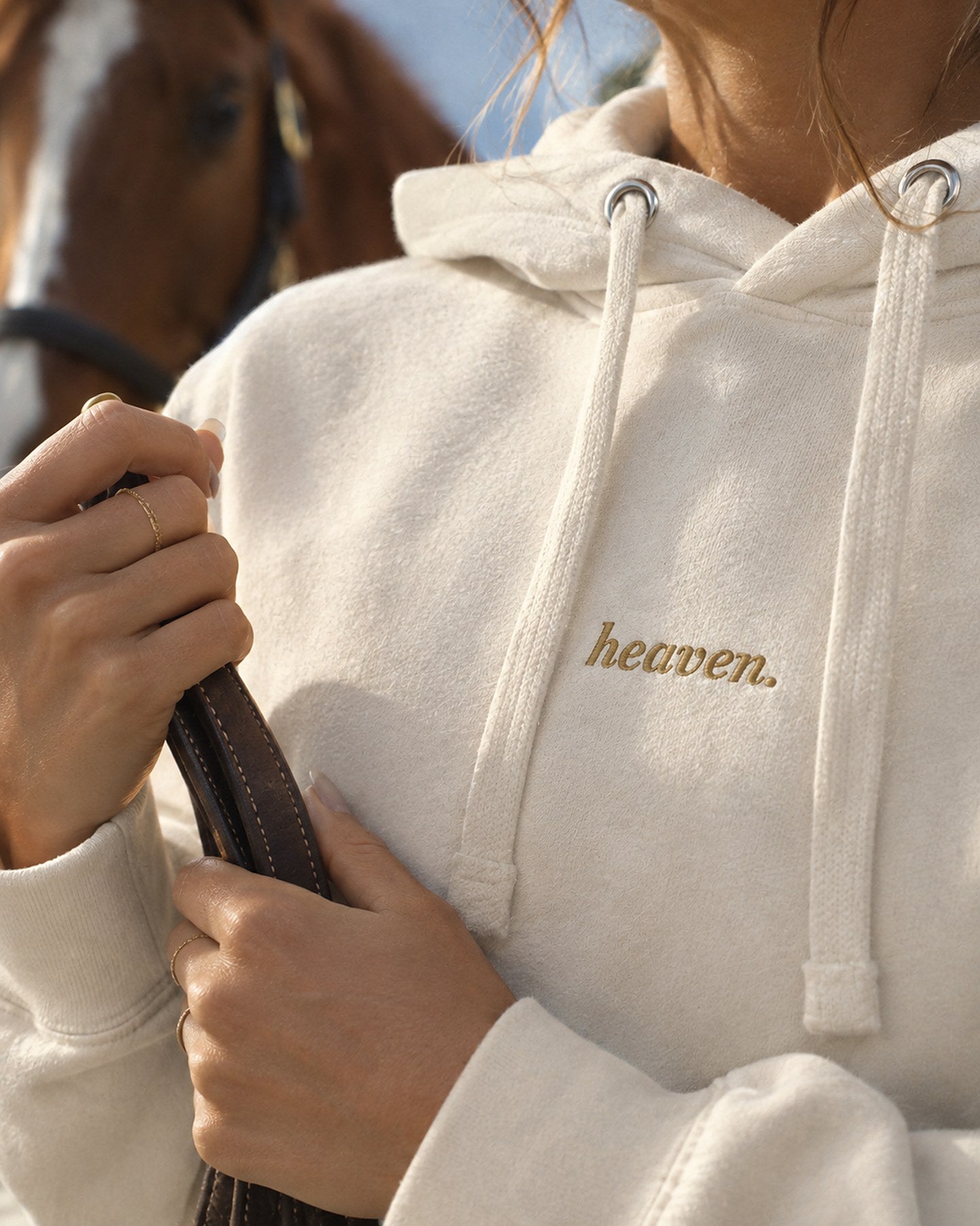 Gros plan sur la broderie heaven. en fil doré et les cordons plats du sweat